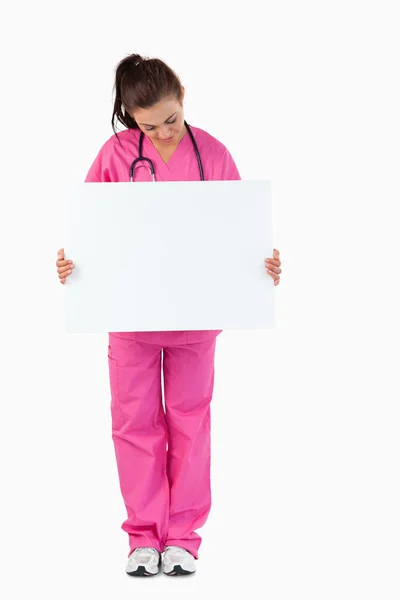 Portrait of a brunette doctor holding a blank panel — Stock Photo, Image