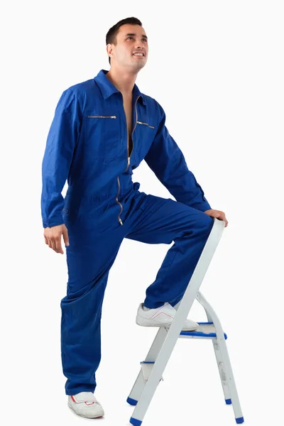 Portrait of a mechanic climbing on a stool — Stock Photo, Image