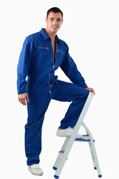 Portrét pohledný mechanik lezení na stoličku — Stock fotografie