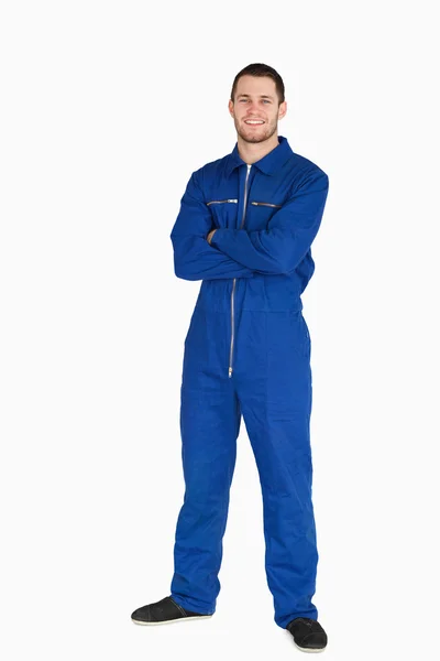 Sorrindo jovem mecânico em terno de caldeira com braços dobrados — Fotografia de Stock