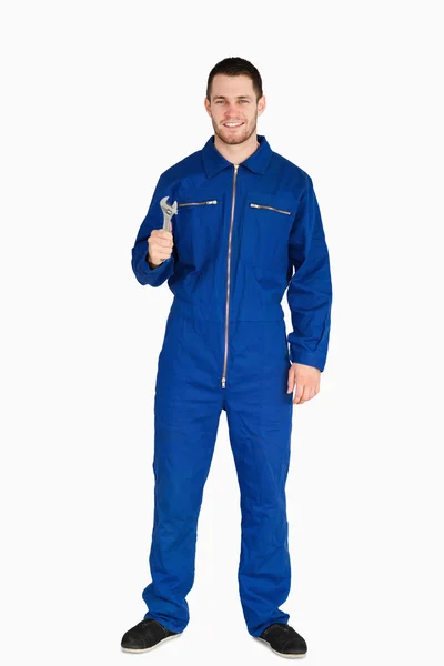 Smiling young mechanic in boiler suit with a wrench — Stock Photo, Image