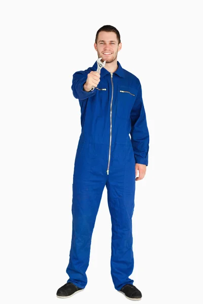 Smiling young mechanic in boiler suit showing his wrench — Stock Photo, Image
