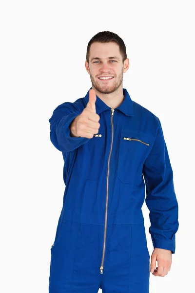 Sorrindo jovem mecânico em terno caldeira dando polegar para cima — Fotografia de Stock