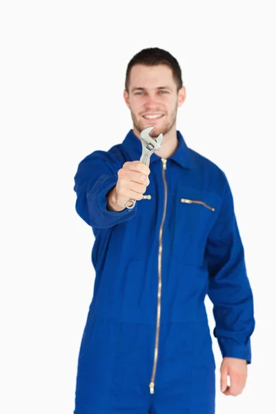 Klíč ukazují smějící se mladí mechanik v kotli obleku — Stock fotografie