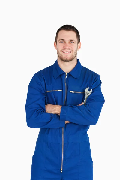 S úsměvem mladá mechanik v kotli obleku s klíčem a zbraní folde — Stock fotografie