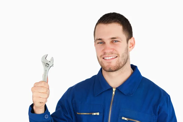 Sonriente joven mecánico sosteniendo su llave inglesa — Foto de Stock