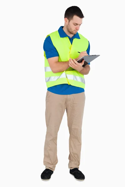 Young male with safety jacket taking notes — Stock Photo, Image