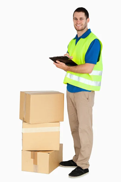 Side view of smiling young delivery man — Stock Photo, Image