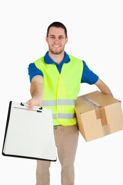 Sorrindo jovem entregador entregando a conta de entrega para signat — Fotografia de Stock