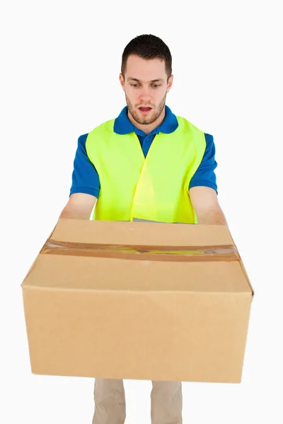 Surprised looking delivery man handing over parcel — Stock Photo, Image