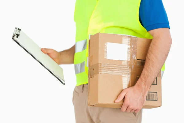 Side view of delivery man with delivery note and parcel — Stock Photo, Image