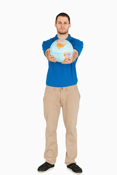 Młody sprzedawca przedstawiania świata z jego rąk — Zdjęcie stockowe