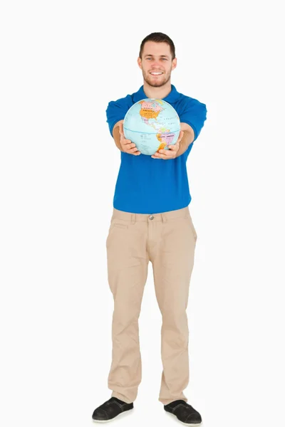 Uśmiechający się młody sprzedawca przedstawiania świata w jego ręce — Zdjęcie stockowe