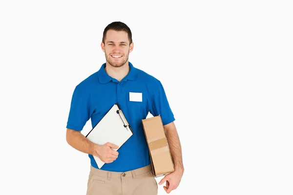 Smiling young salesman with parcel and clipboard — Stock Photo, Image