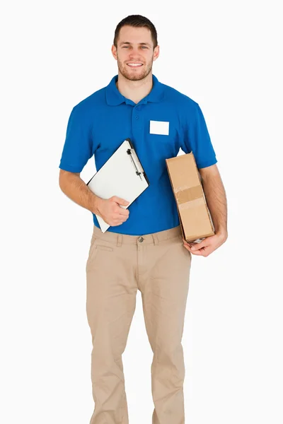 Sonriente joven vendedor con paquete y portapapeles — Foto de Stock