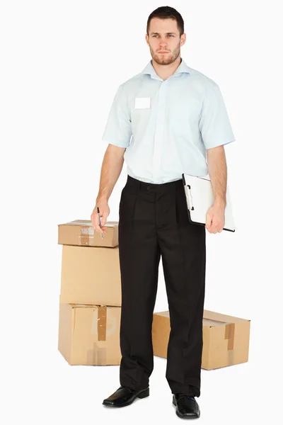 Junge Post-Mitarbeiterin mit Paketen und Klemmbrett — Stockfoto