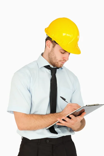 Young lead worker writing on his clipboard — Stock Photo, Image