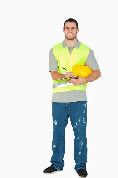 Sorrindo jovem trabalhador da construção com área de transferência — Fotografia de Stock
