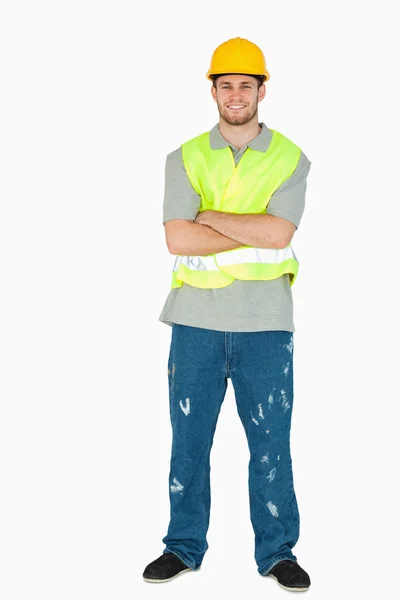 折り畳まれた腕を持つ若い建設労働者の笑みを浮かべて — ストック写真