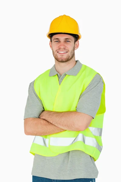 Sorrindo jovem trabalhador da construção civil com braços dobrados — Fotografia de Stock
