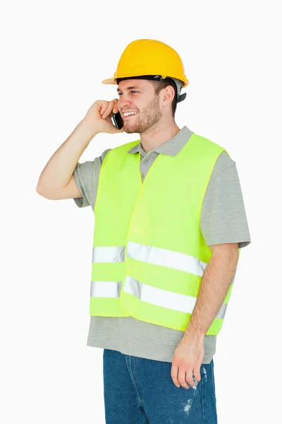 Sonriente joven trabajador de la construcción en el teléfono celular —  Fotos de Stock