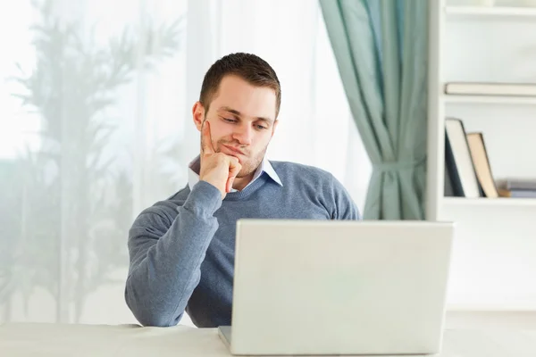 Empresário em seu laptop em pensamentos em seu escritório em casa — Fotografia de Stock