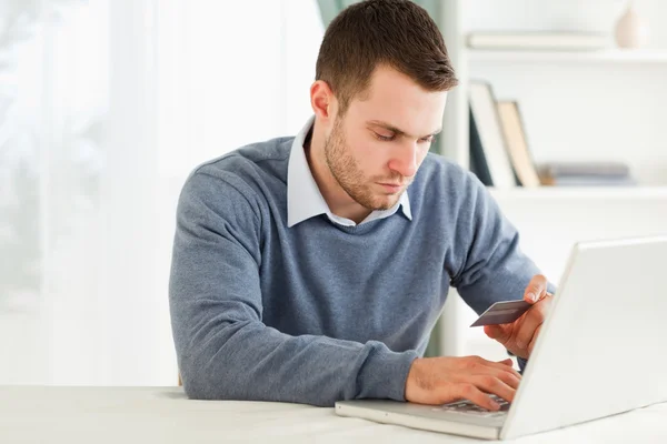 Masculino inserindo informações de cartão de crédito em seu laptop — Fotografia de Stock