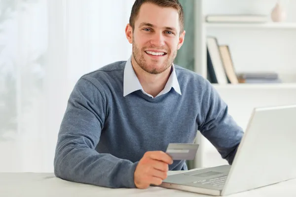 Мужчина с кредитной картой в ноутбуке — стоковое фото