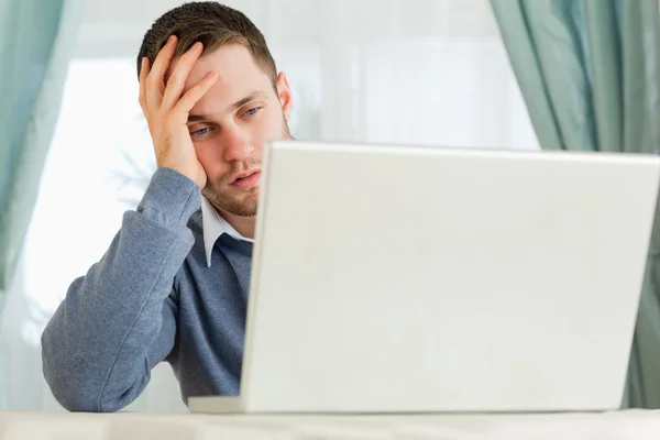 Empresário irritado com seu laptop em seu escritório em casa — Fotografia de Stock