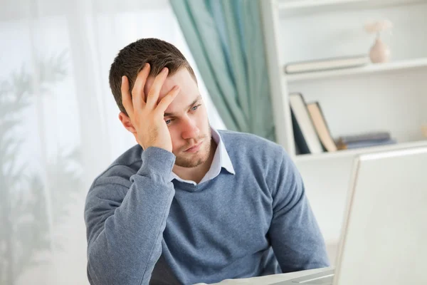 Homem cansado em seu laptop — Fotografia de Stock