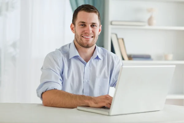 Geschäftsmann mit hochgekrempelten Ärmeln auf seinem Laptop in seiner Wohnung — Stockfoto