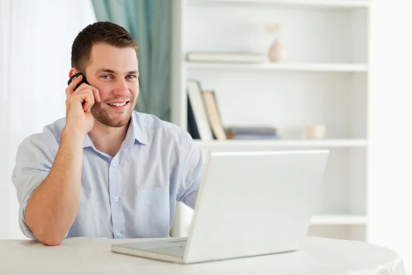 Lächelnder Geschäftsmann am Telefon in seinem Homeoffice — Stockfoto