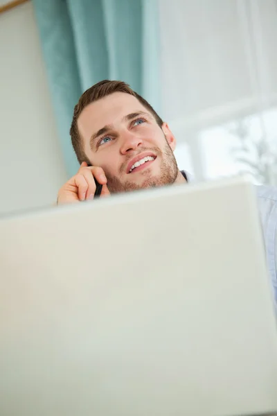 Молодой бизнесмен разговаривает по телефону в своем офисе — стоковое фото