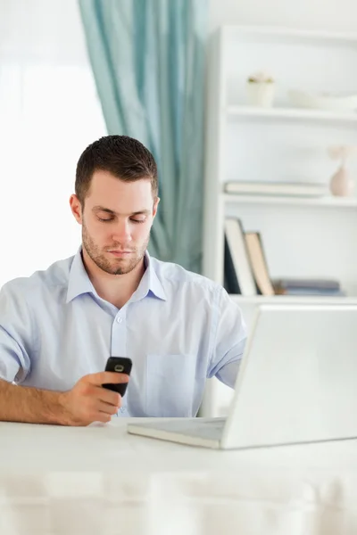 Homme d'affaires textos sur son téléphone portable dans son bureau à domicile — Photo