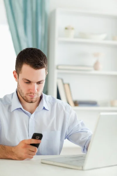 Бизнесмен читает текстовые сообщения в своем офисе — стоковое фото