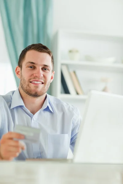 Affärsman med kreditkort och anteckningsbok i hans homeoffice — Stockfoto