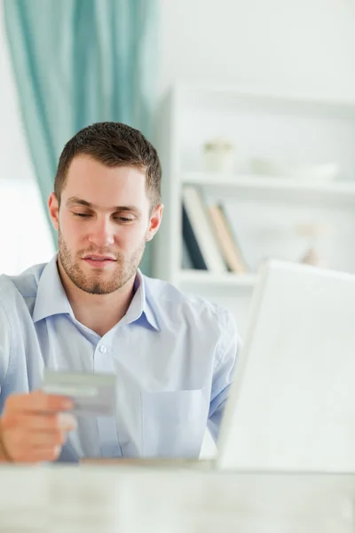 Бизнесмен с ноутбуком и кредитной картой в своем офисе — стоковое фото