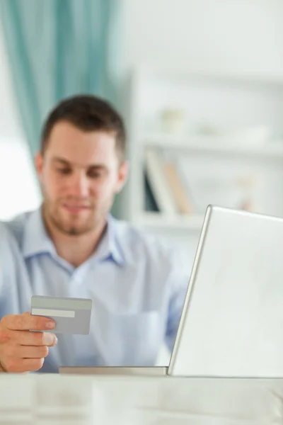 Homme d'affaires avec ordinateur portable et carte de crédit dans son bureau à domicile — Photo