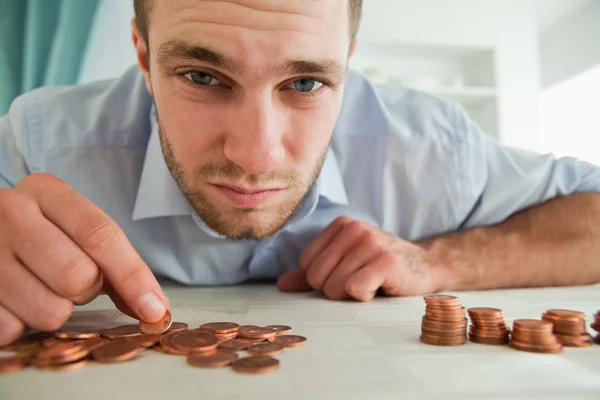 Desperate businessman counting his change — Stock Photo, Image