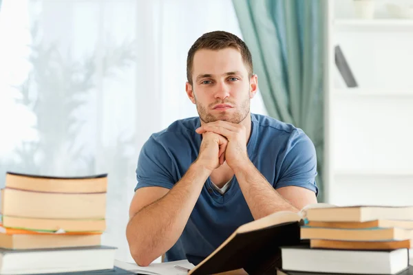 Student sitter vid sitt skrivbord tänkande — Stockfoto