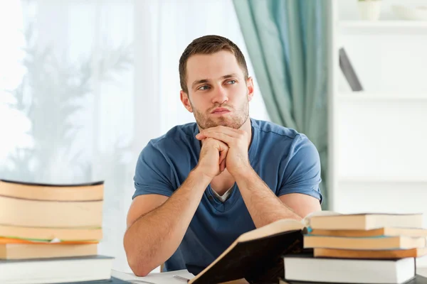 Student sitting at his desk in thoughts — Stock Photo, Image