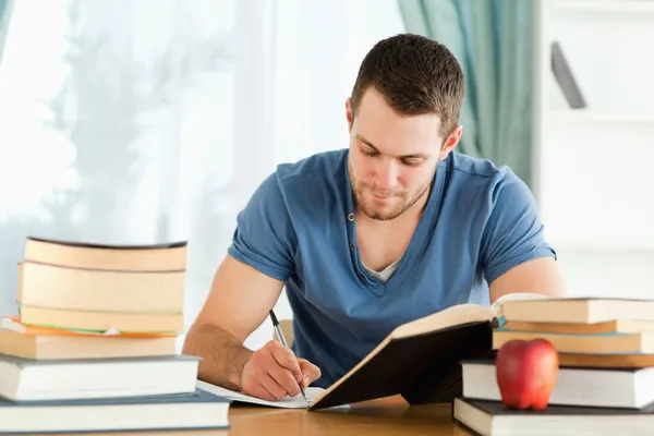 Student werkt door middel van zijn boeken — Stockfoto