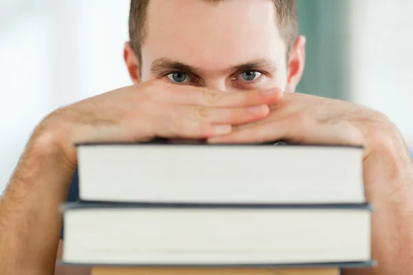 Student verstopt achter een stapel boeken — Stockfoto