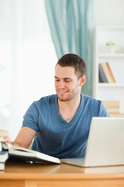 stock image Student using the internet for his book report