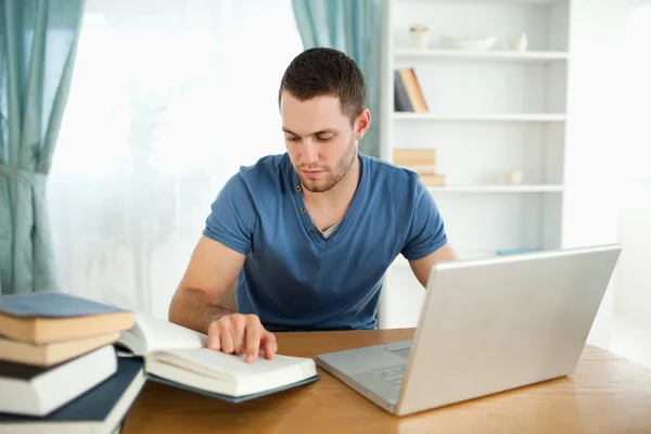 Studerande använder sin laptop för att arbeta igenom hans angående material — Stockfoto