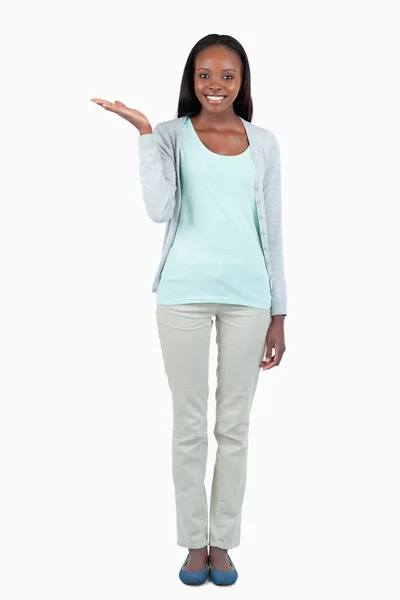 Smiling young woman holding her palm upwards — Stock Photo, Image