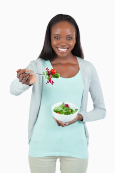 Junge Frau bietet etwas Salat an — Stockfoto
