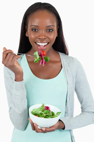 Souriante jeune femme mangeant de la salade — Photo