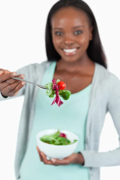 Salade aangeboden door lachende jonge vrouw — Stockfoto