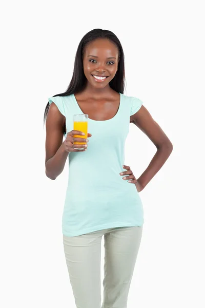 Улыбающаяся молодая женщина со стаканом апельсинового сока — стоковое фото